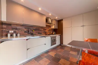 a kitchen with white cabinets and a tile floor at A Casa del Gioielliere in Palermo