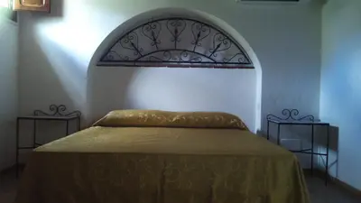 a bedroom with a bed with an arch above it at Baglio Poma in Castelluzzo