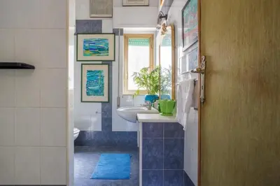 a bathroom with a sink and a toilet and a window at Artist penthouse 2 in Palermo