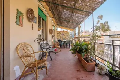a balcony with chairs and tables on a building at Artist penthouse 2 in Palermo