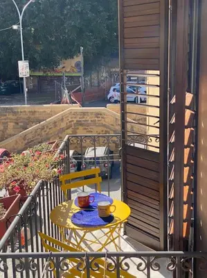 a yellow table and chairs on a balcony at Casamartú Apartment in Palermo