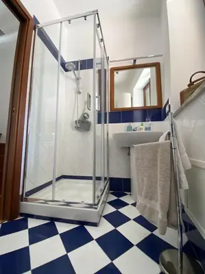 a bathroom with a shower and a checkered floor at Casamartú Apartment in Palermo