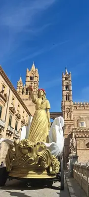 a statue of a woman riding a cart in front of a building at Casamartú Apartment in Palermo