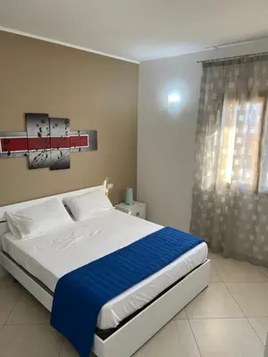 a bedroom with a large bed with a blue blanket at Mare Blu Apartament in Balestrate