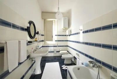 a blue and white bathroom with two toilets and a sink at Villa Paradiso in Castelluzzo