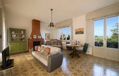 a living room with a couch and a tv and a table at Villa Paradiso in Castelluzzo