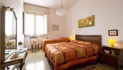 a bedroom with a bed and a table and a desk at Villa Paradiso in Castelluzzo