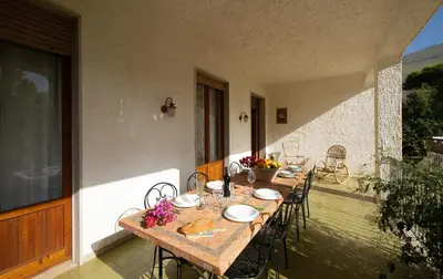 a table and chairs sitting on a balcony with a table and chairs at Villa Paradiso in Castelluzzo