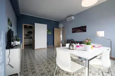 a dining room with blue walls and a white table and chairs at Sea Sicily View in Bagheria