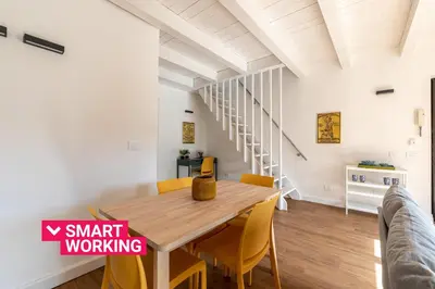 a dining room with a wooden table and yellow chairs at Casa Valverde in Centro Storico by Wonderful Italy in Palermo