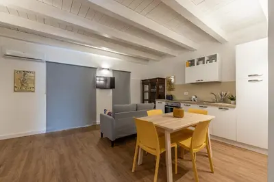 a kitchen and a living room with a table and chairs at Casa Valverde in Centro Storico by Wonderful Italy in Palermo