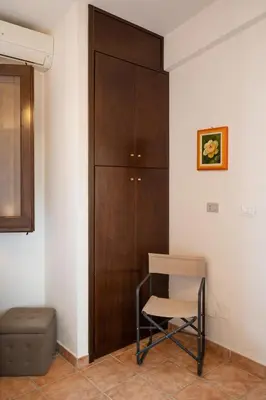 a chair and a cabinet in a room at Villa Carilù in Altavilla Milicia