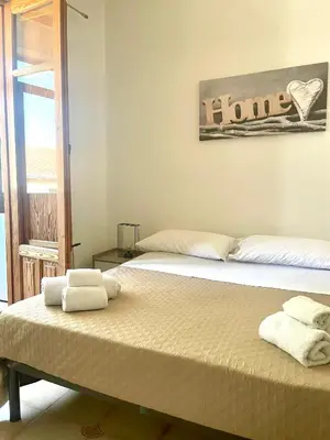 two beds in a room with towels on them at Villa Nasus in Carini