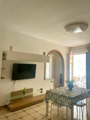 a living room with a table and a tv at Villa Nasus in Carini