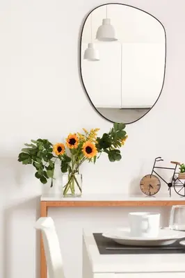 a table with a mirror and a vase of sunflowers at Serendipity room & relax in Palermo