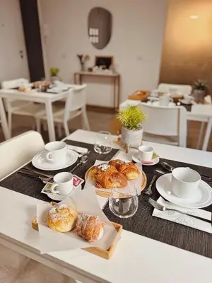 a table with plates of pastries and cups on it at Serendipity room & relax in Palermo