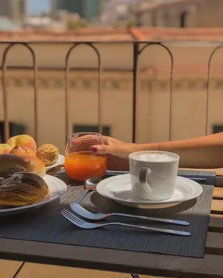 a table with a plate of food and a cup of coffee at Serendipity room & relax in Palermo
