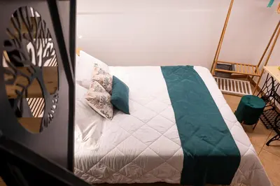 a bed with a green and white blanket and pillows at Teama House - Appartamento in centro - Politeama in Palermo
