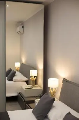 a bedroom with two beds and a large mirror at Holiday hause Vite Aerea in Terrasini