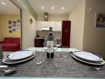 a table with a bottle of wine and glasses on it at A casa di Alli in Palermo