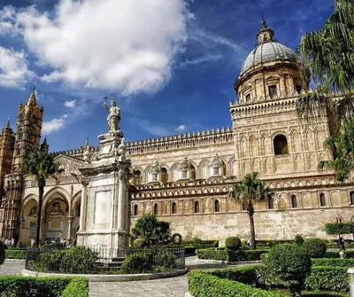 a large building with a statue in front of it at A casa di Alli in Palermo