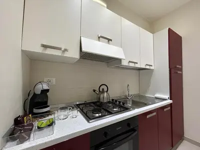 a kitchen with white cabinets and a stove top oven at A casa di Alli in Palermo