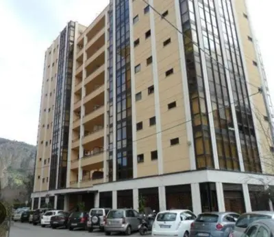 a large building with cars parked in front of it at Cleotto residence case vacanza in Palermo