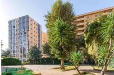 a park with palm trees in front of a building at Cleotto residence case vacanza in Palermo