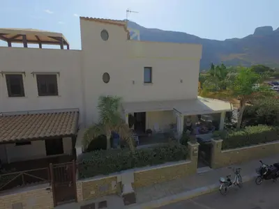 a white house with people standing outside of it at Athena Bed & Breakfast in San Vito lo Capo