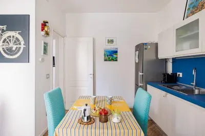 a small kitchen with a table and a refrigerator at Lucky Home Palermo in Palermo