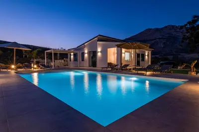 a swimming pool in front of a house at night at Villa Aurora in Balata di Baida