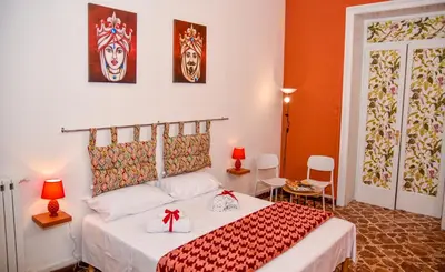 a bedroom with a bed with a red and white blanket at Alba e i Mori in Palermo