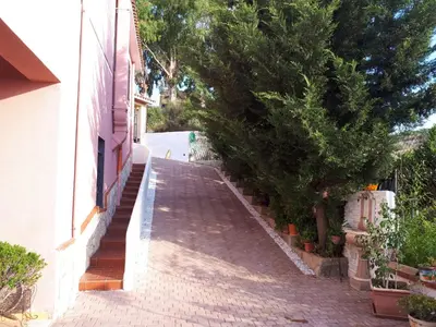 a brick sidewalk next to a building with trees at Villetta dei Tramonti in Trappeto