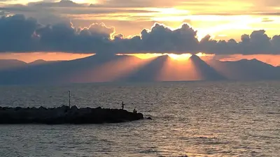a group of people on a pier in the ocean at sunset at Villetta dei Tramonti in Trappeto