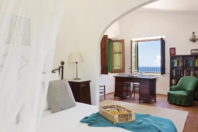 a bedroom with a bed with a table and a desk at Villa La Fenice by Wonderful Italy in Castellammare del Golfo