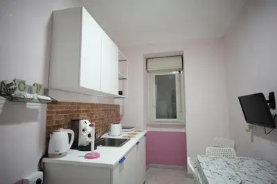 a small white kitchen with a sink and a window at Casa Vacanze Madison Square in Palermo