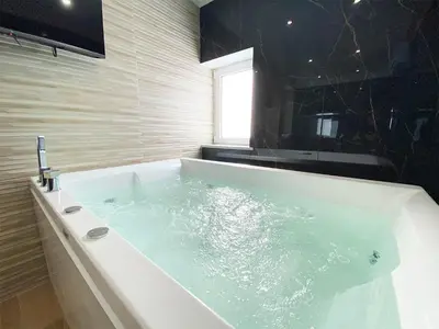 a bathroom with a bath tub with a window at Dimora Sicula Relais - Palermo in Palermo