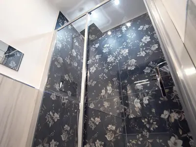 a bathroom with a shower with floral wallpaper at Dimora Sicula Relais - Palermo in Palermo