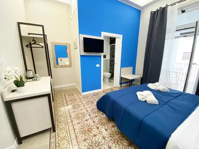 a blue bedroom with a bed and a bathroom at Dimora Sicula Relais - Palermo in Palermo