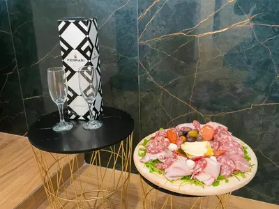 a plate of food on a table next to a wine glass at Dimora Sicula Relais - Palermo in Palermo