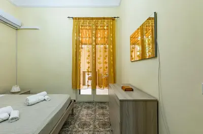a room with two beds and a desk and a window at Teatro Massimo Roomy Flat with Covered Terrace in Palermo