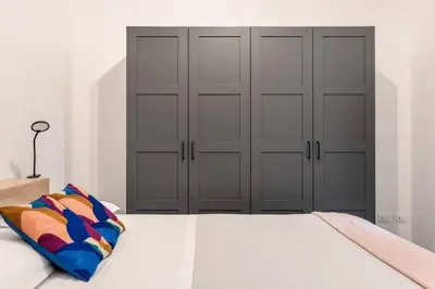 a bedroom with two sets of closet doors and a bed at Terrazza San Domenico in Palermo