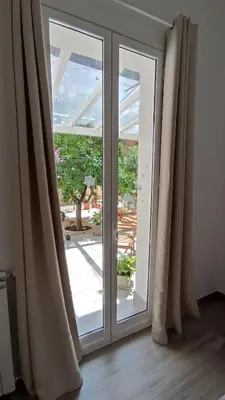 a sliding glass door with a view of a patio at Tati's Garden in Palermo