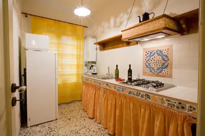 a kitchen with a white refrigerator and a stove at Sicilia Ovest - Domus Mariae Charming Apartments with Balcony in Castellammare del Golfo