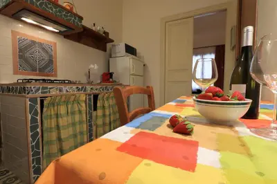 a kitchen with a table with a bowl of strawberries on it at Sicilia Ovest - Domus Mariae Charming Apartments with Balcony in Castellammare del Golfo