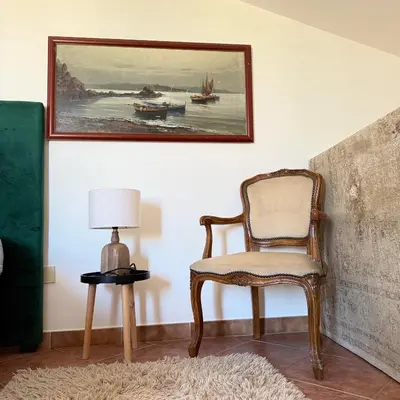 a chair in a room with a picture on the wall at Donna Isabella a Ballarò in Palermo