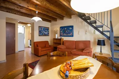 a living room with a table and chairs and a staircase at Hola House allo Spasimo in Palermo