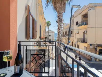 a glass of wine sitting on a table on a balcony at Apartment Sicilia by Interhome in Balestrate