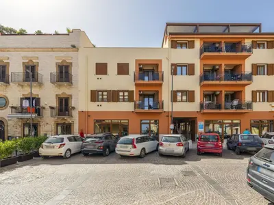 a parking lot with cars parked in front of a building at Apartment Sicilia by Interhome in Balestrate