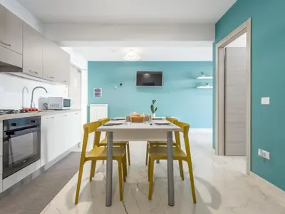 a kitchen with a white table and yellow chairs at Apartment Sicilia by Interhome in Balestrate